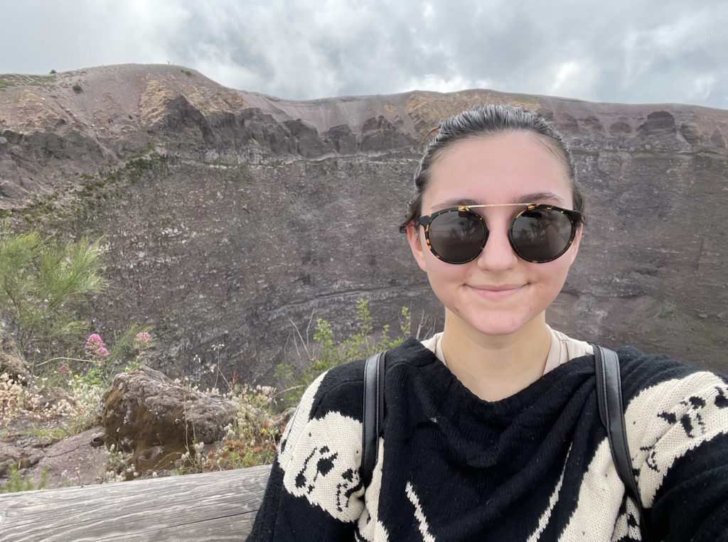 Alex (sweaty and red) smiling in front of the crater of Vesuvius