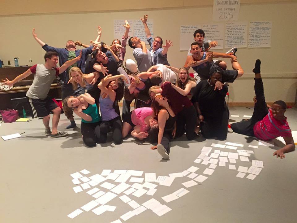 group of people doing funny poses with flashcards strewn in front of them