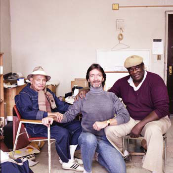 three men sitting and smiling