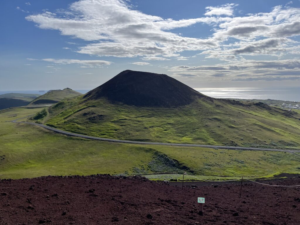 Photo of the volcano Helgafell on Heimaey Island, taken while standing on top of the Eldfell, the neighboring younger volcano that erupted in 1975.